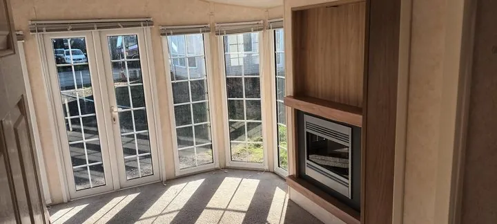 Lounge with double doors, bay windows and a fireplace